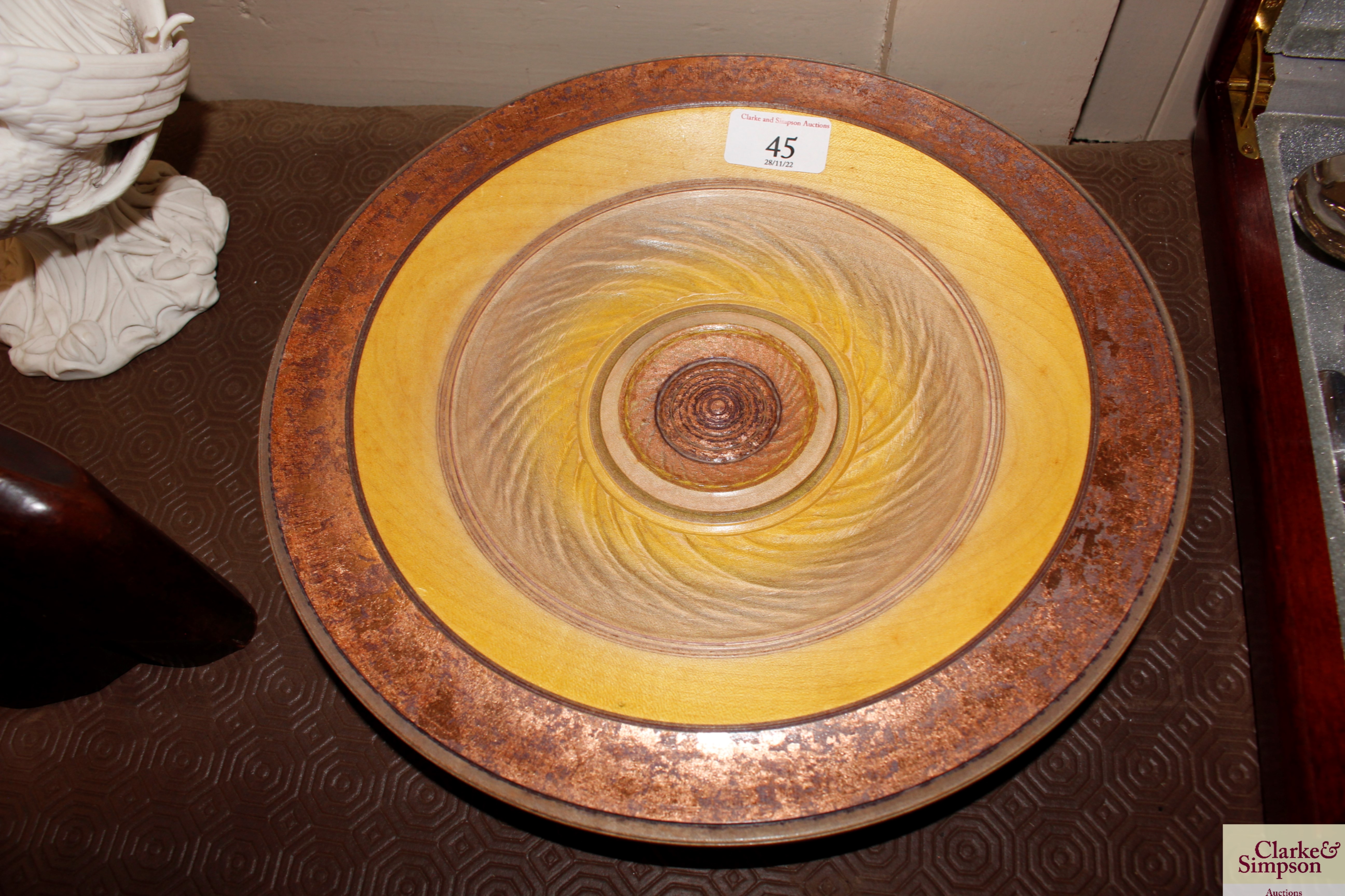 A turned wooden and decorated bowl, signature to b