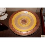 A turned wooden and decorated bowl, signature to b