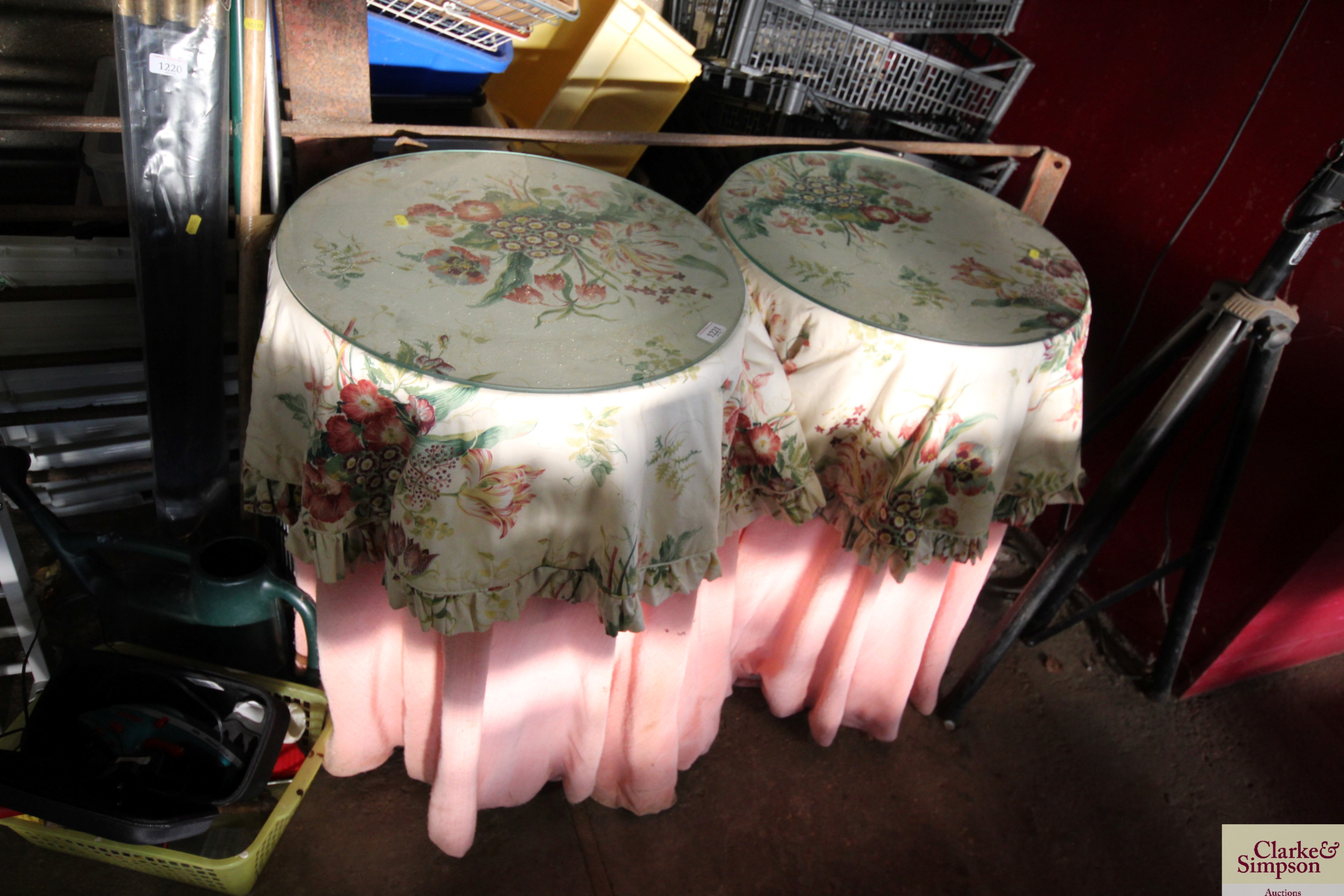 A pair of bedside tables with glass tops and curta