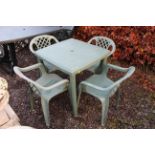 A green plastic garden table and four chairs