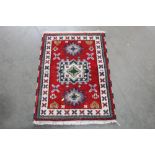 An approx.3'1" x 2'1" red and blue pattern rug