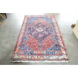 An approx. 7'1" x 4'3" Persian red and blue patter