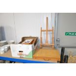 An artists easel, artists box, a box of various ar