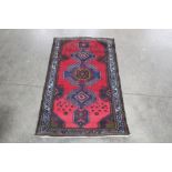 An approx. 4'1" x 2'4" blue and green pattern rug