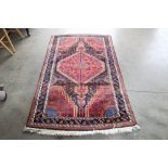 An approx. 6'5" x 3'8" red pattern rug
