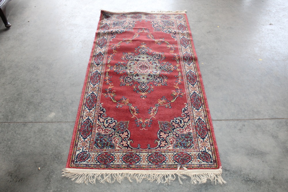 An approx. 6'3" x 7' red pattern rug