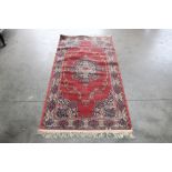 An approx. 6'3" x 7' red pattern rug