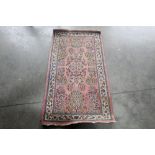 An approx. 4'5" x 2'3" pink and blue pattern rug