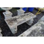 A concrete garden seat on lion-decorated plinth