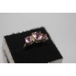 A white metal and triple pink stone set dress ring