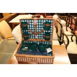 A wicker picnic hamper and contents