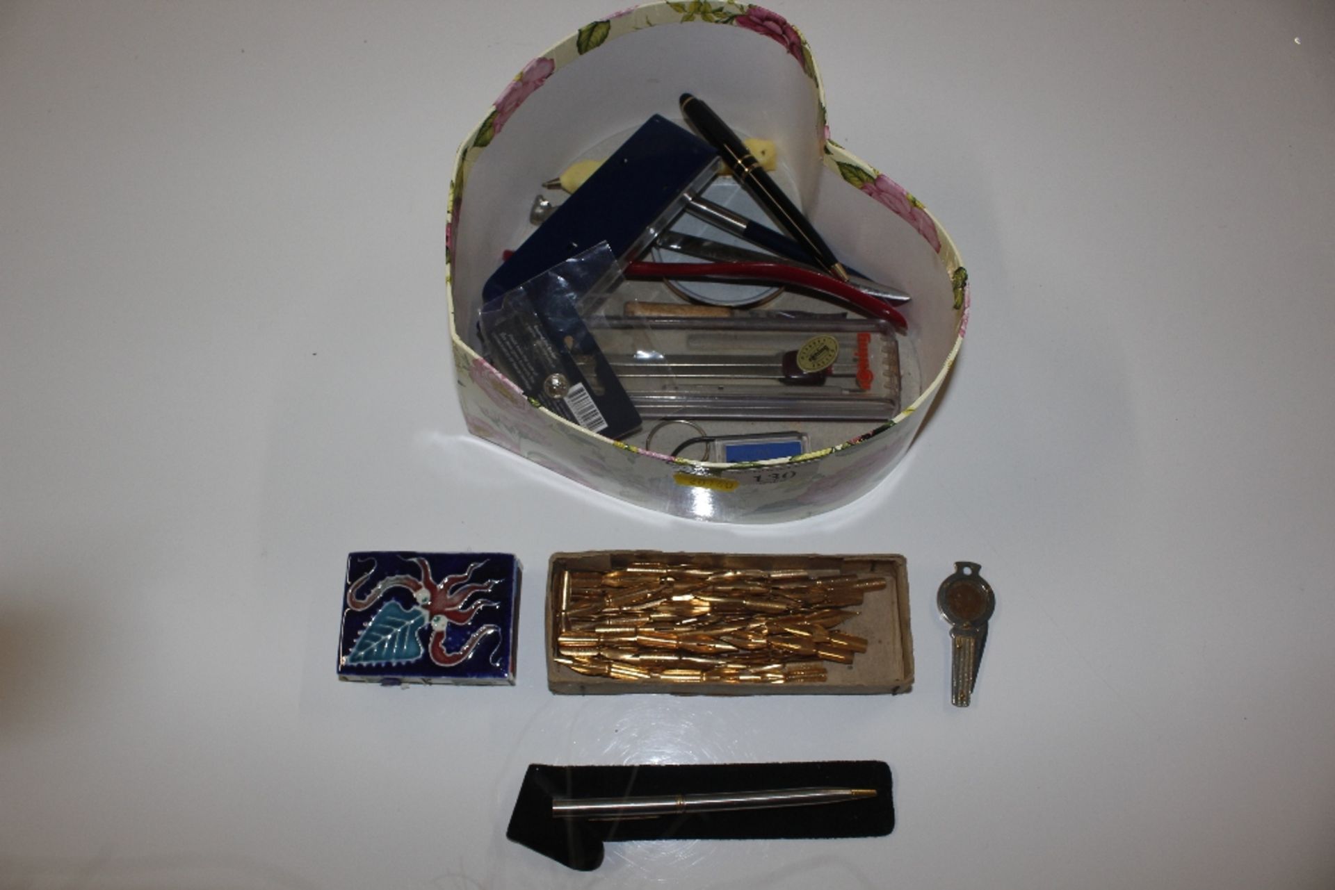 A box containing souvenir spoons, pen knife, match