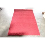 An aprox 5'5" x 3'9" red patterned rug