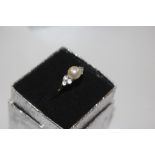 A pearl and white stone set dress ring