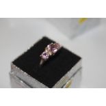 A white metal and triple pink stone set dress ring