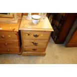 A modern pine bedside chest fitted three drawers