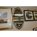 A brass framed bevel edged oval wall mirror