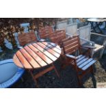 A folding slatted garden table and a set of four m