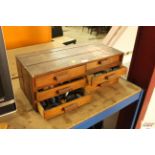 A small six drawer wooden cabinet containing reels of cotton