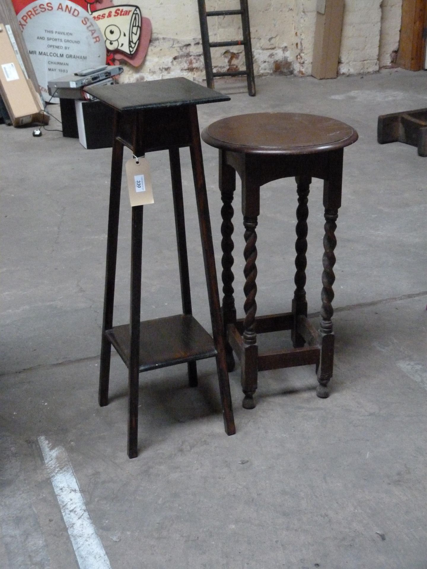 A tall round side table with barley twist legs and plant stand