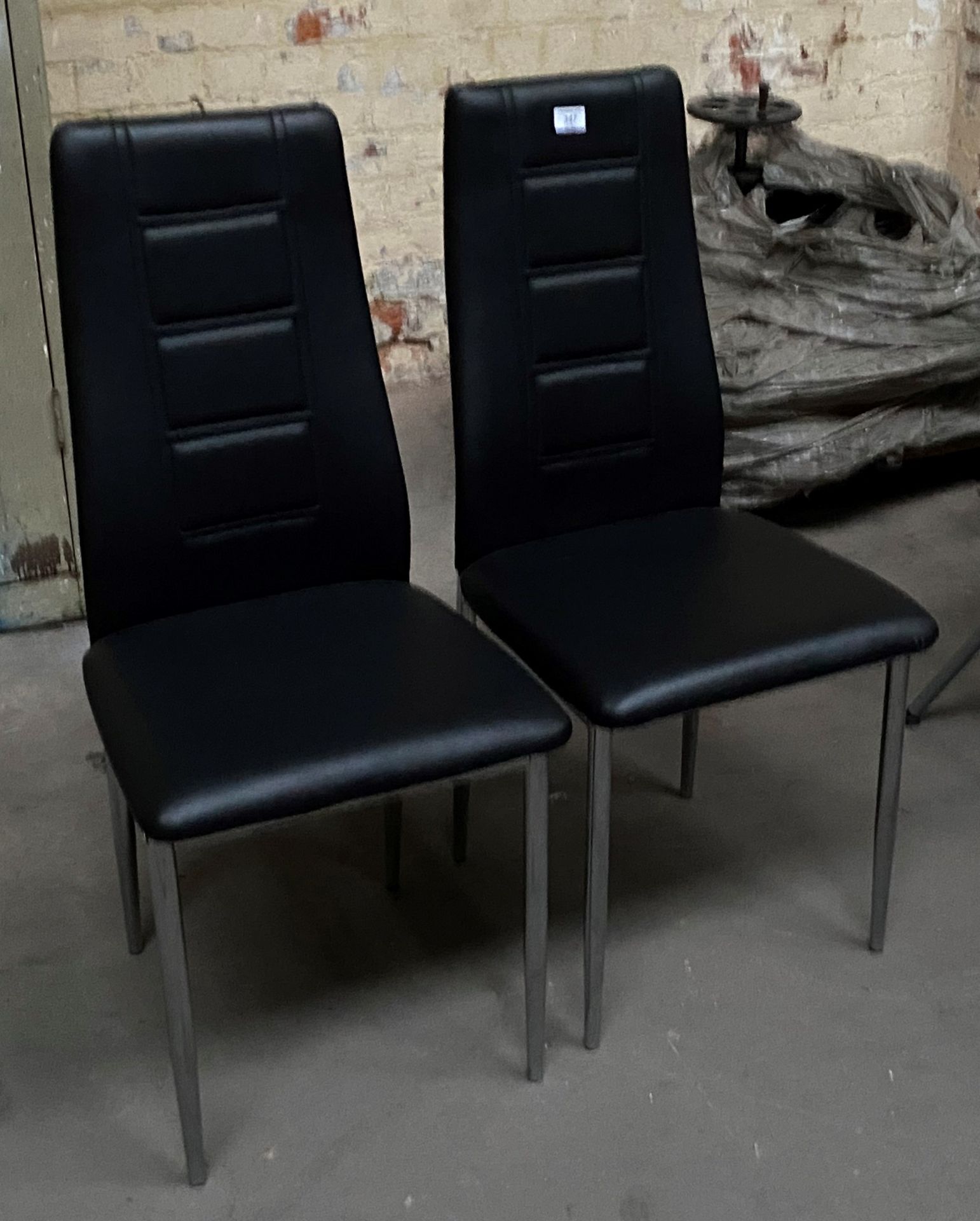 Two black faux leather dining chairs