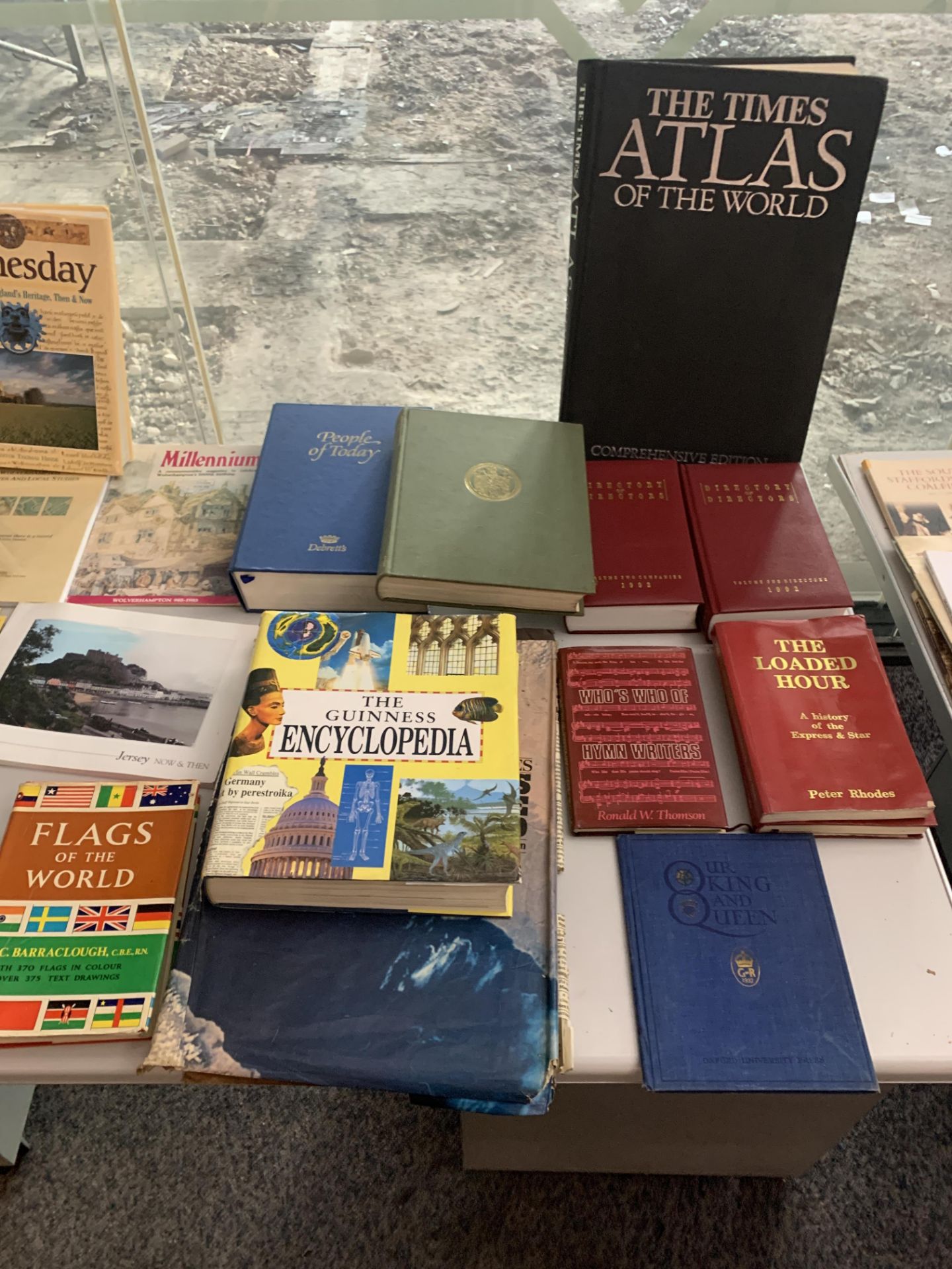 A collection of books including Encyclopedias, History, Flags of the World and Atlases.