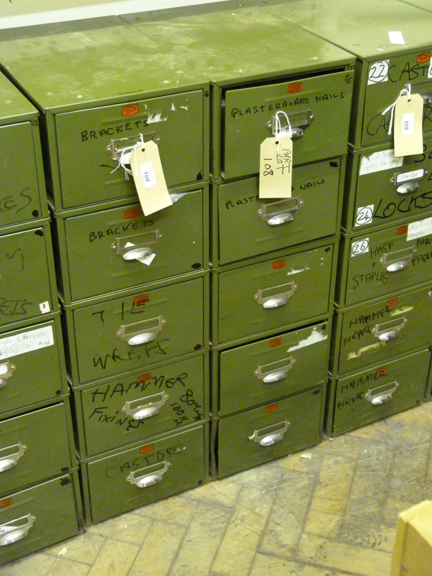 Two Veteran Series green metal five drawer units and contents to include brackets, fixings,