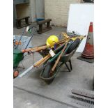 A wheel barrow and a quantity of garden tools to include rakes, long reach lopper,