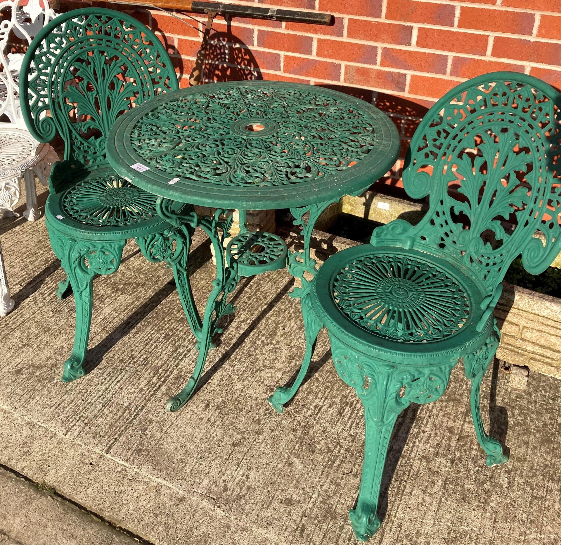 A green painted aluminium circular patio table 70cm diameter and two matching chairs