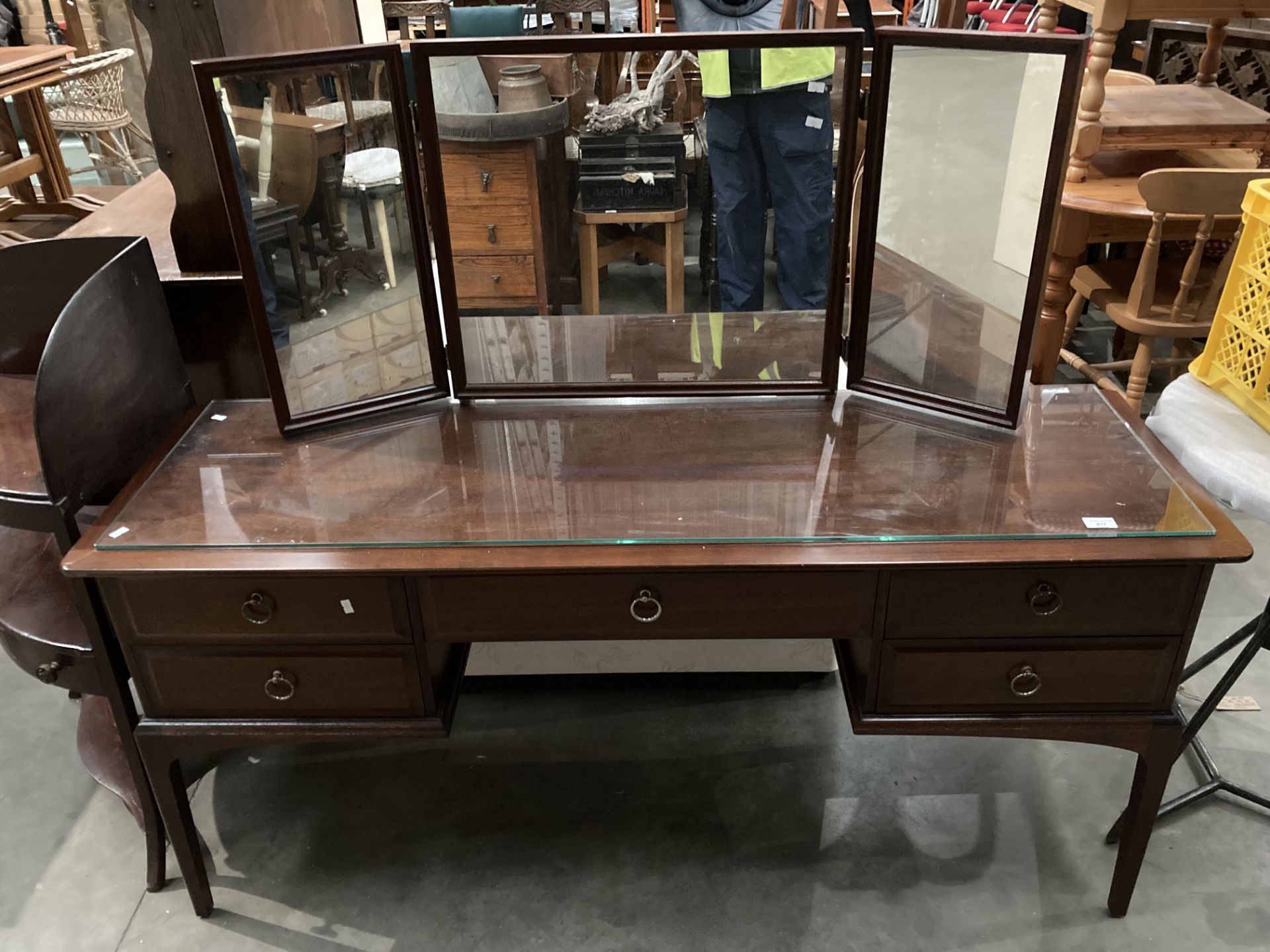 A Stag mahogany finish five drawer dressing table with triple mirror back and protective glass top,