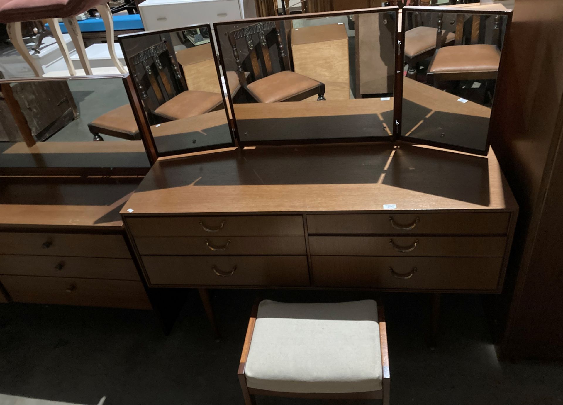 A mahogany finish six drawer mirror back dressing table,