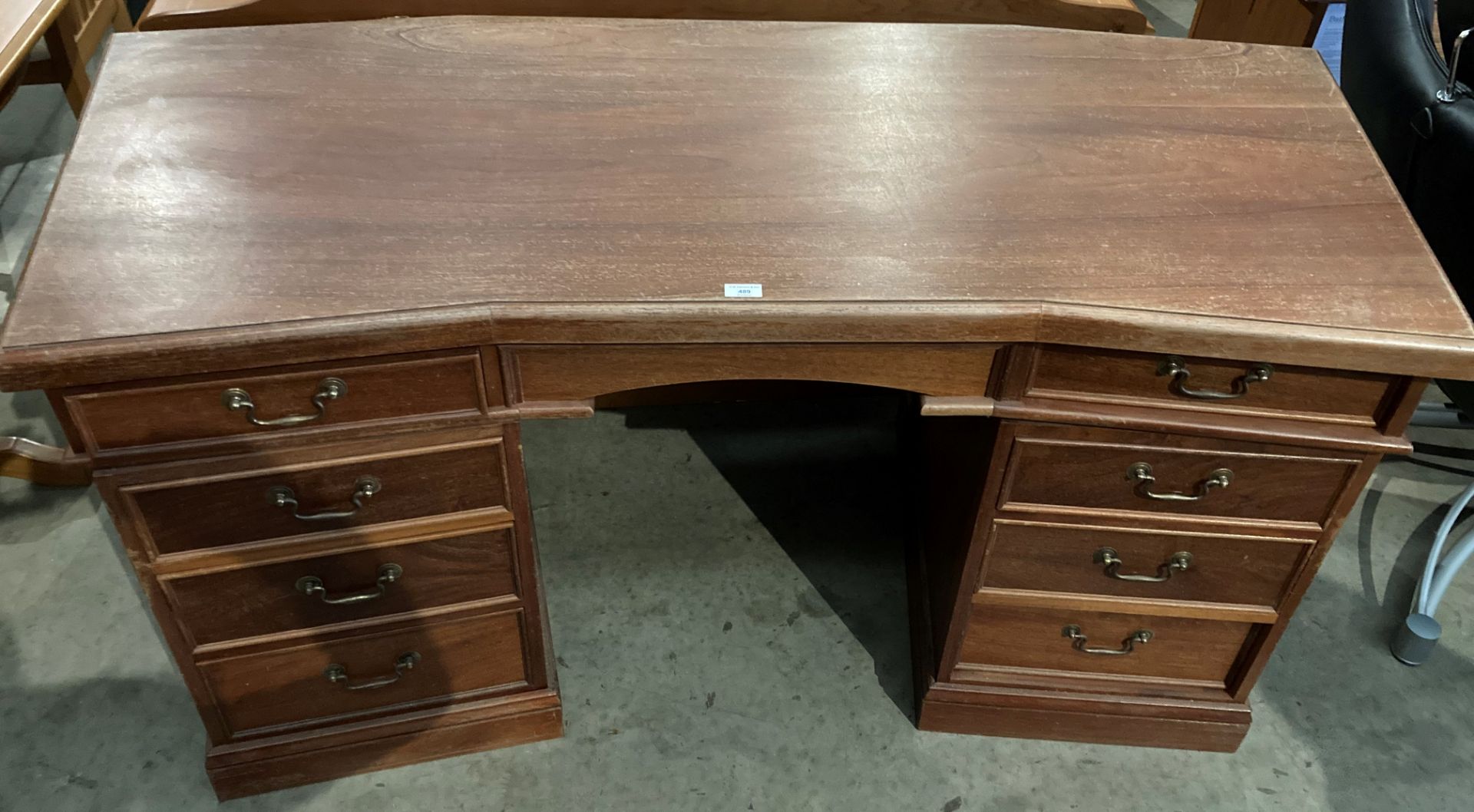 A mahogany shaped top twin pedestal eight drawer desk 150 x 68cm