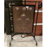 A wrought iron and copper fire screen