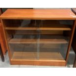 A teak low bookcase with two glass sliding doors,