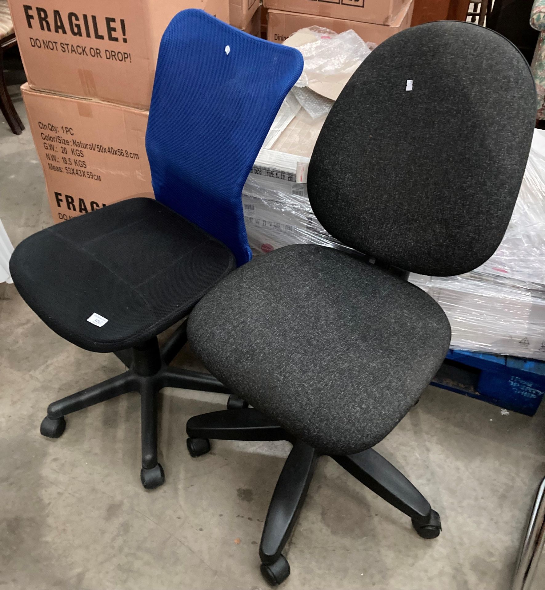 An operators black and blue upholstered swivel chair and a charcoal grey swivel office chair (2)