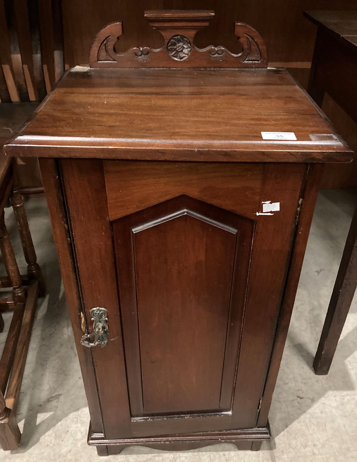 A mahogany single door bedside cupboard