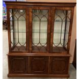 A reproduction mahogany display cabinet with three tracery glazed doors over three single drawer