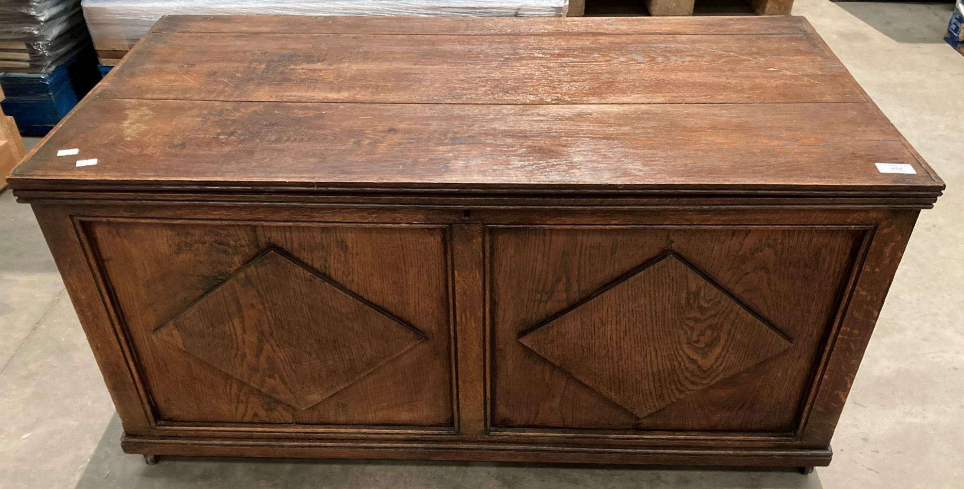 An oak blanket box with carved panel front,