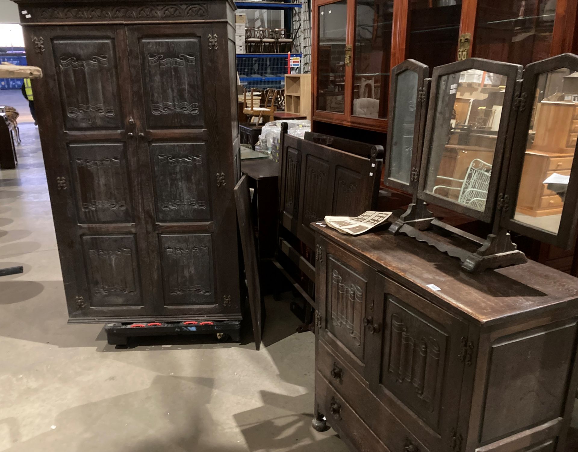 A dark oak carved four piece bedroom suite with linen fold panels comprising two door wardrobe