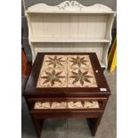 A nest of three mahogany finish coffee tables with tiled tops and a small cream painted wall rack