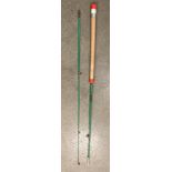 A two piece green fishing rod approximately 7' long and a metal pole and blue bag