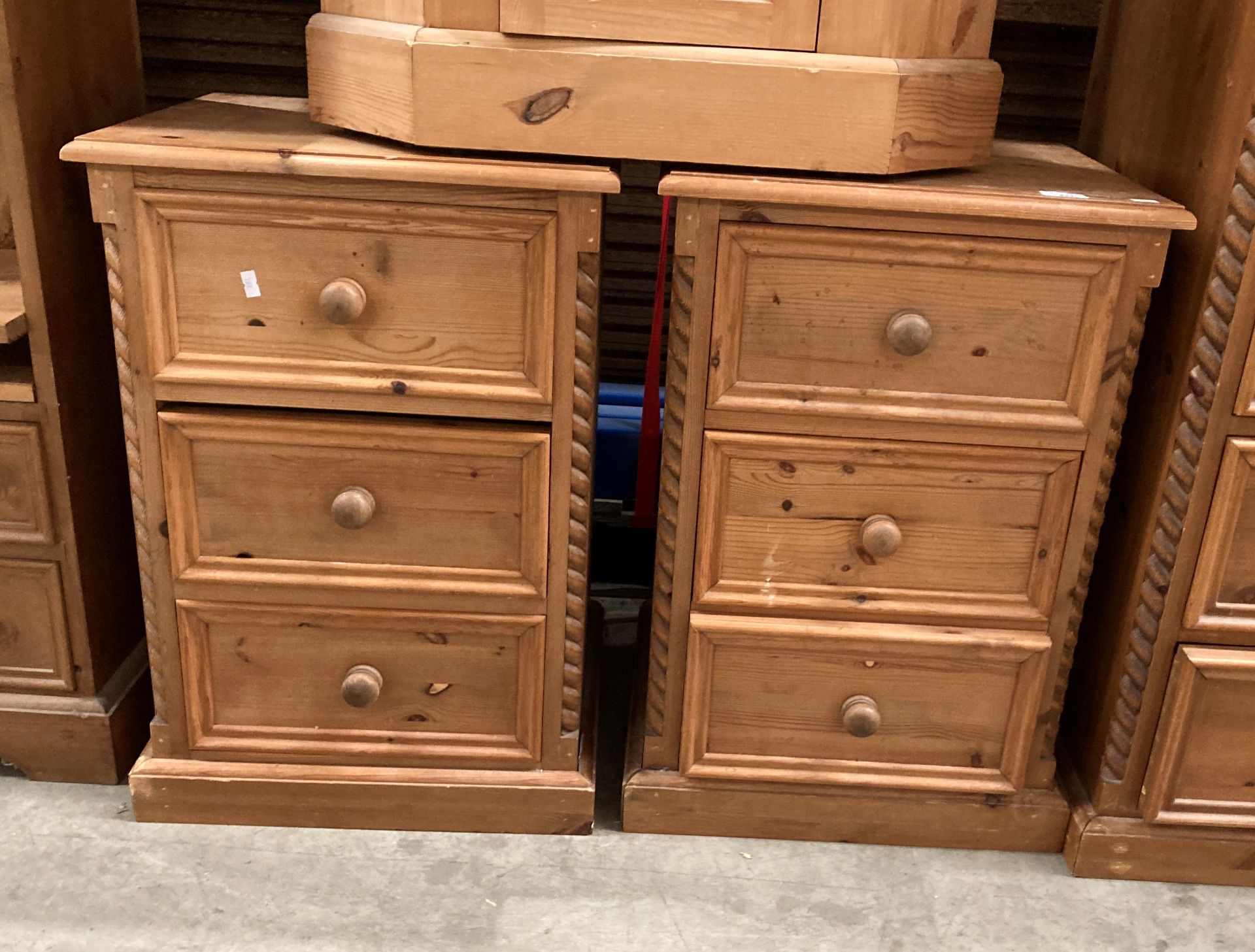 A pair of pine three drawer bedside cabinets to match lot 222