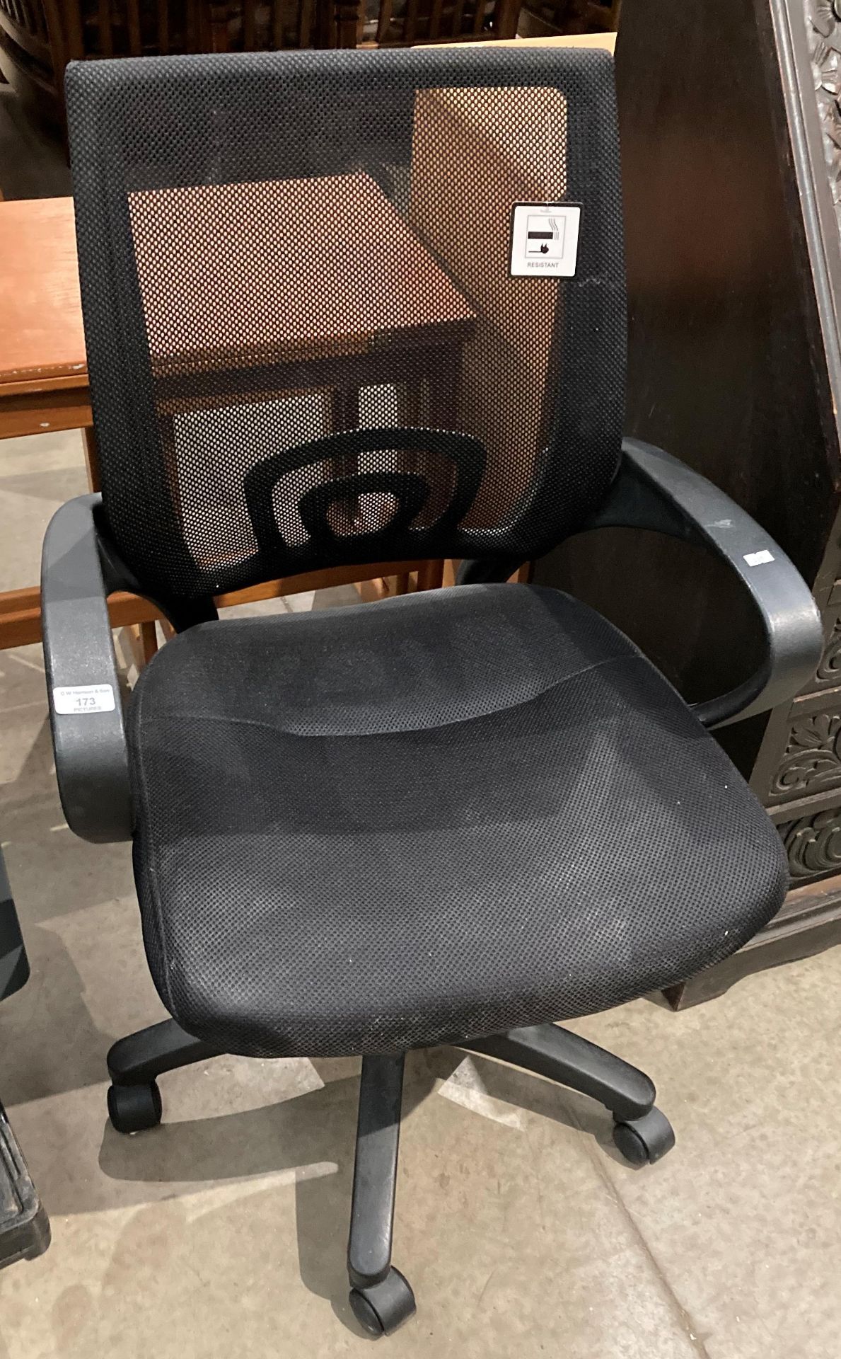 A charcoal grey operators swivel armchair with mesh back