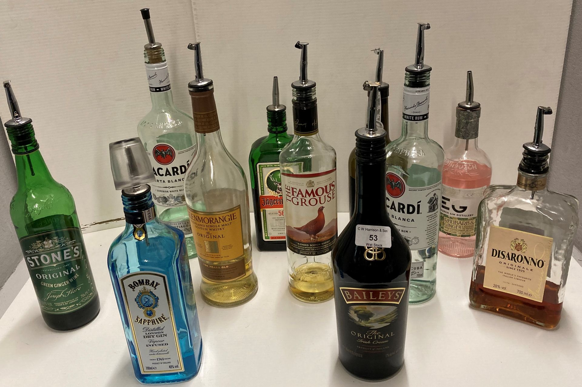 11 x part bottles of assorted spirits (complete with pourers) including Bacardi, Disaronno,