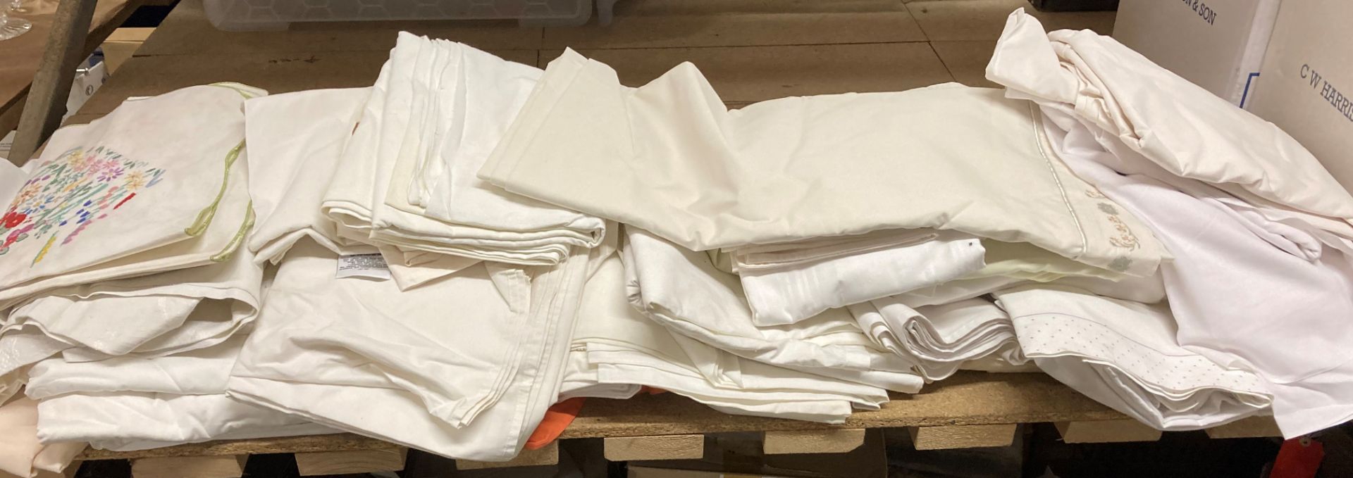 Contents to part of rack - a large quantity of mainly white linen tablecloths/bedding