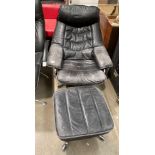 A black leather swivelling chrome framed recliner chair with ottoman (leather worn and faded)