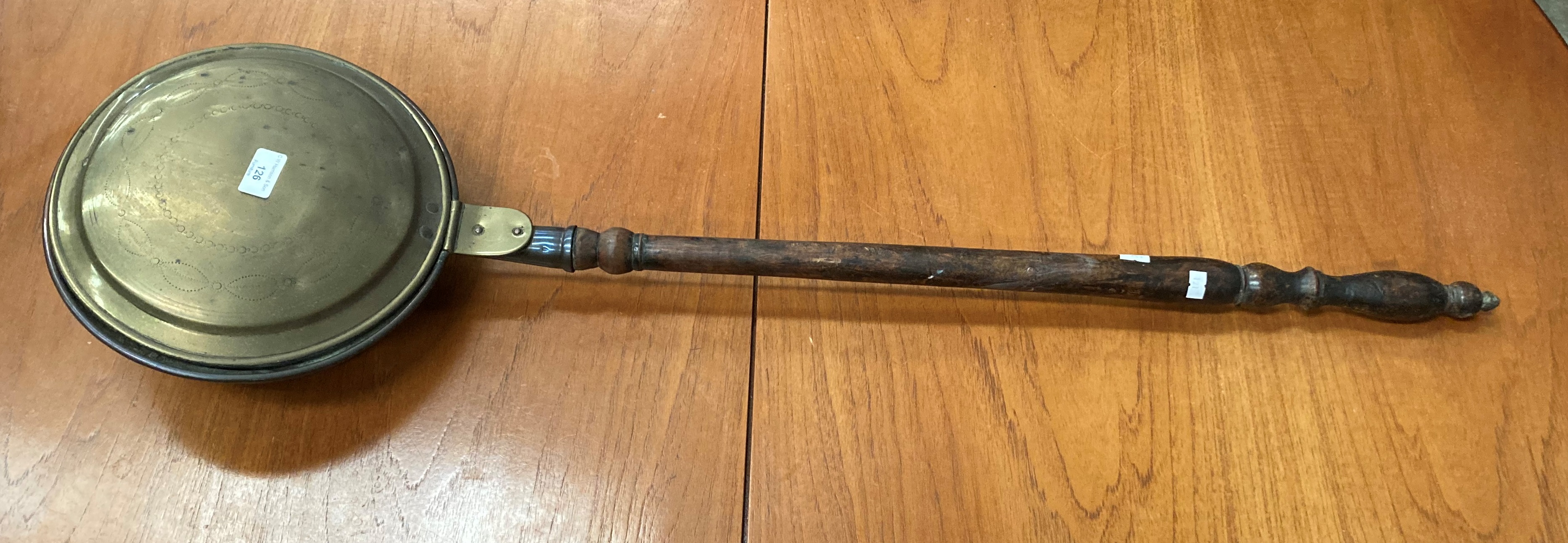 A brass and copper bed warmer with long wood handle