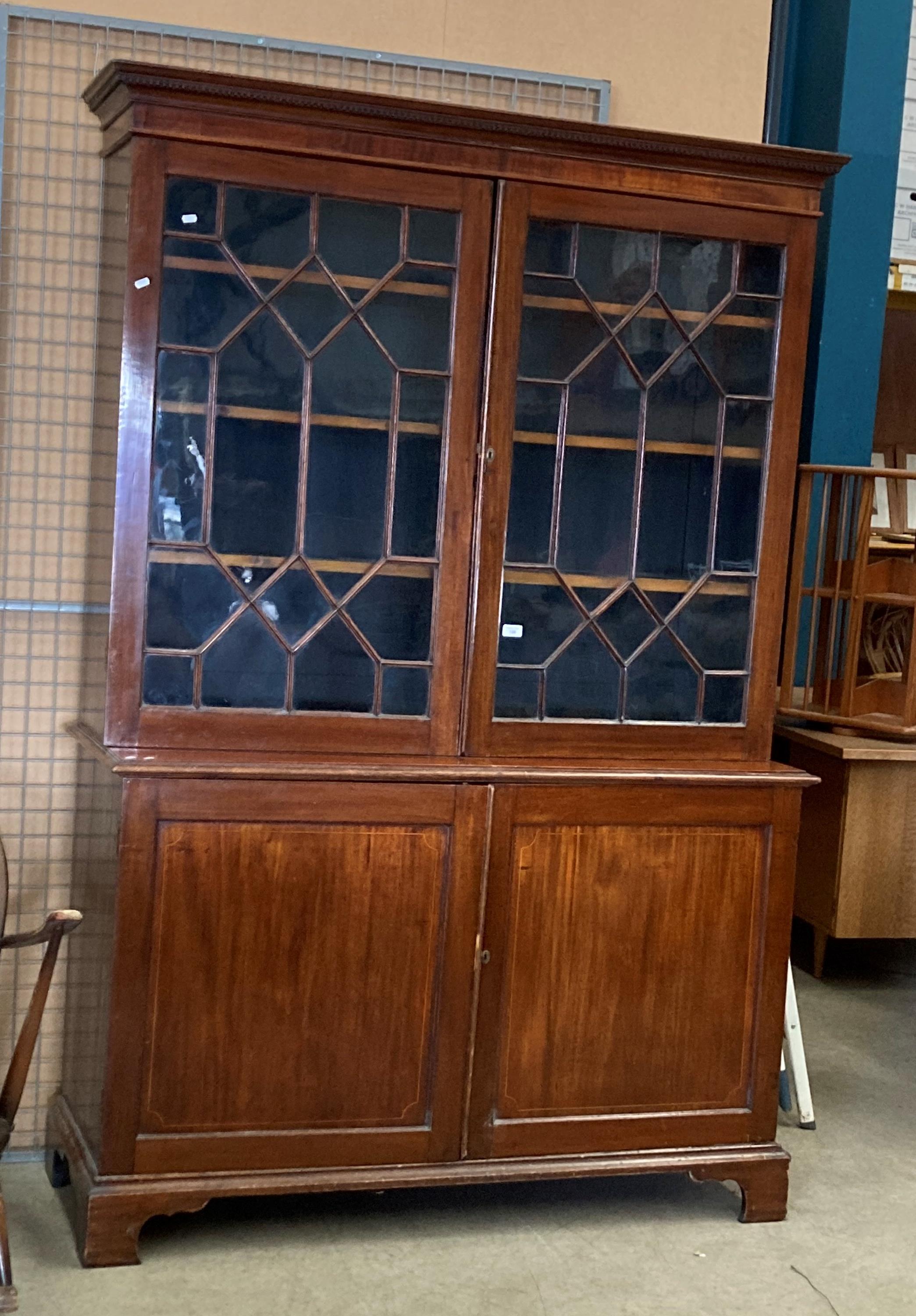 A large mahogany bookcase/wall unit with two Astragal glazed doors over two door base 140cm x 210cm