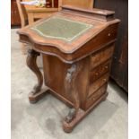 A walnut Davenport with green tooled leather lift top with four drawers to one side and four dummy