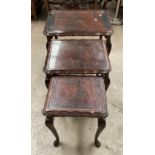 A nest of three mahogany coffee tables with glass inset tops